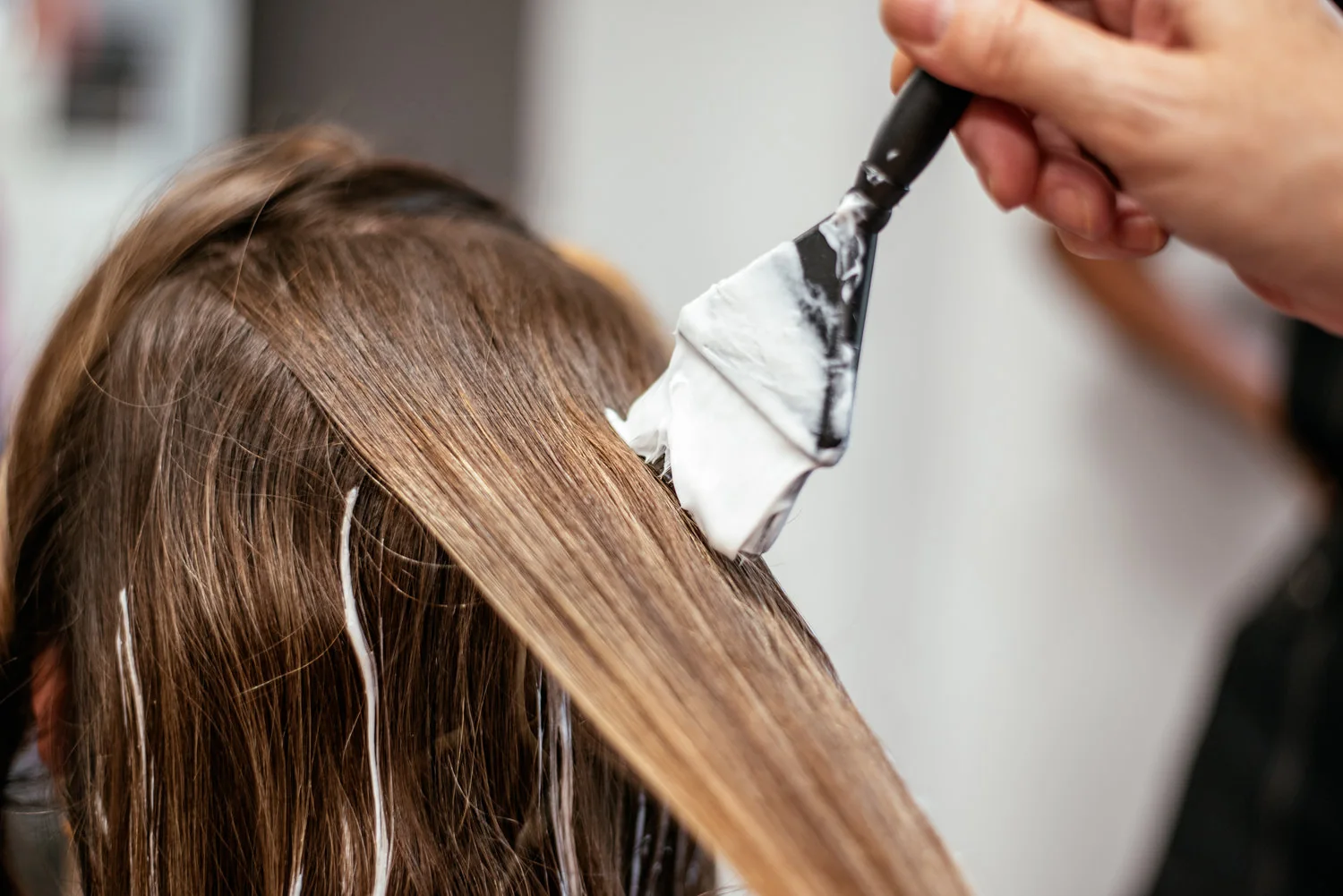 Profesional aplicando coloración de cabello en salón