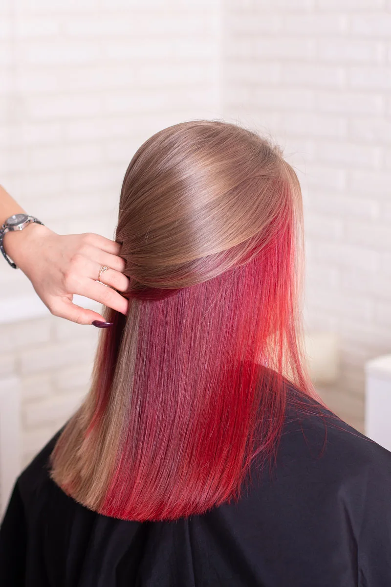 Cabello castaño con secciones rojas durante una corrección de color