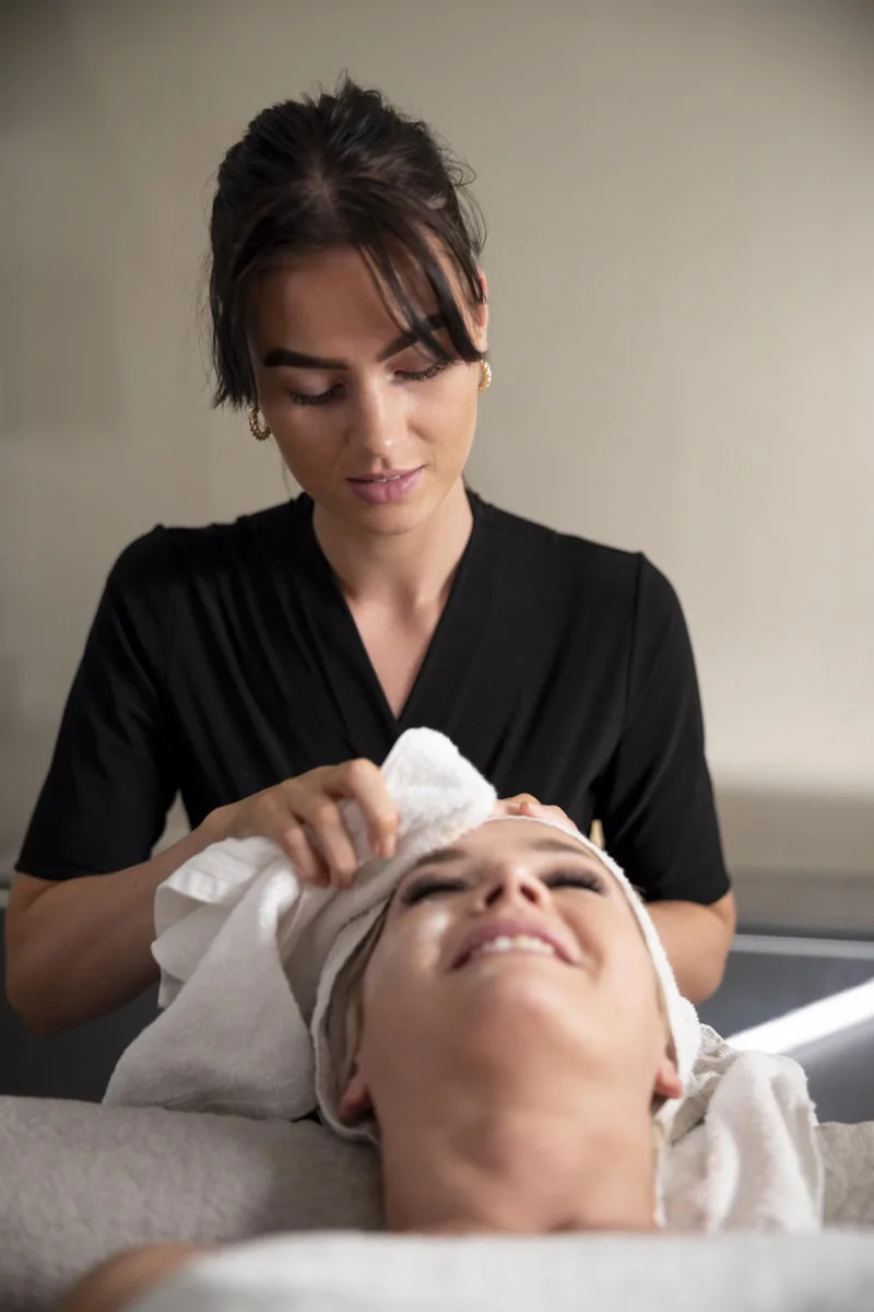 Profesional evaluando y limpiando la piel del rostro