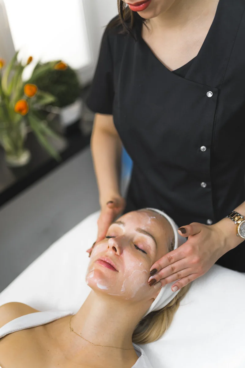 Mujer recibiendo un masaje facial suave en un centro de belleza