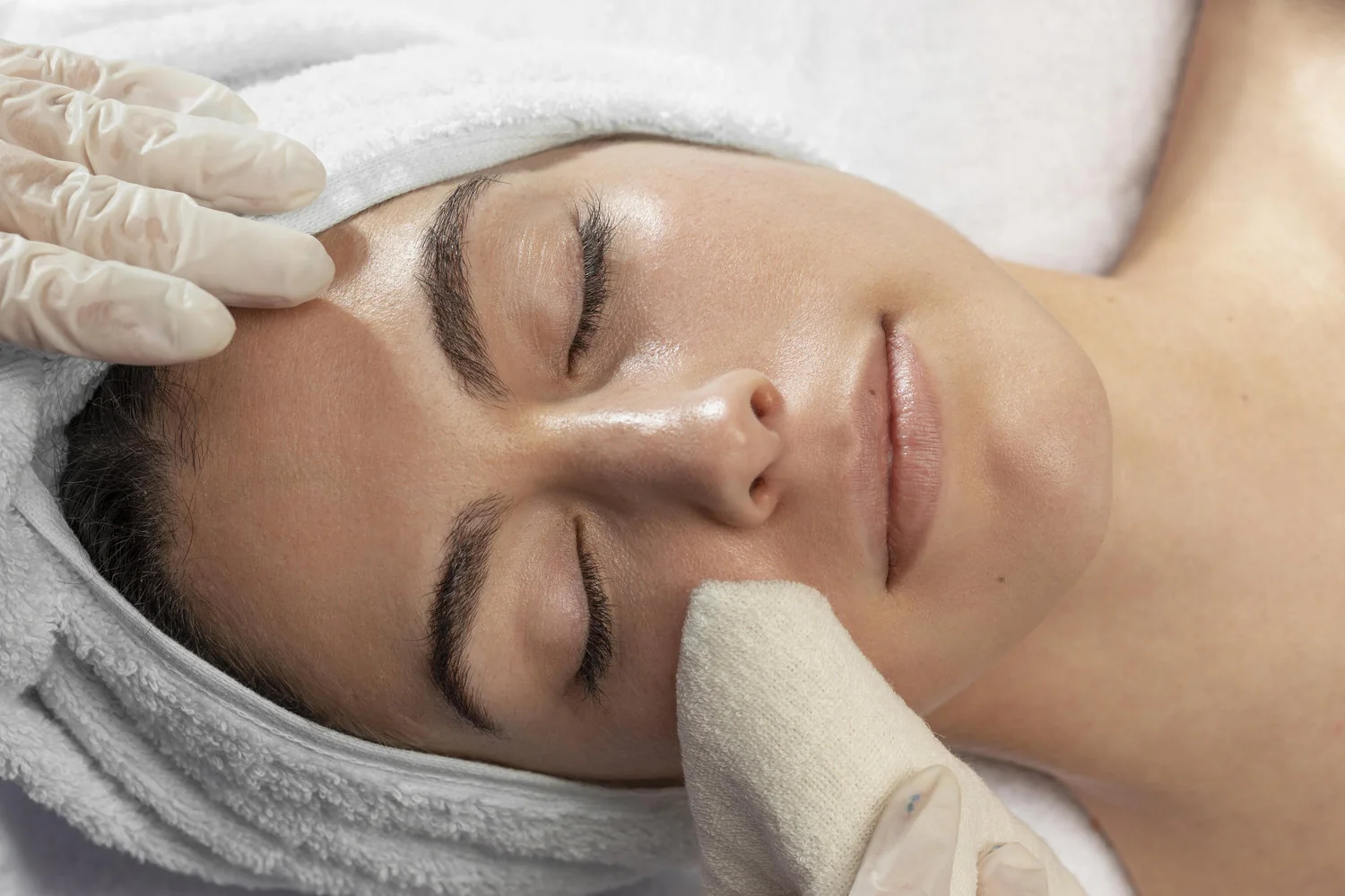 Mujer recibiendo una atención de limpieza facial en un centro de estética