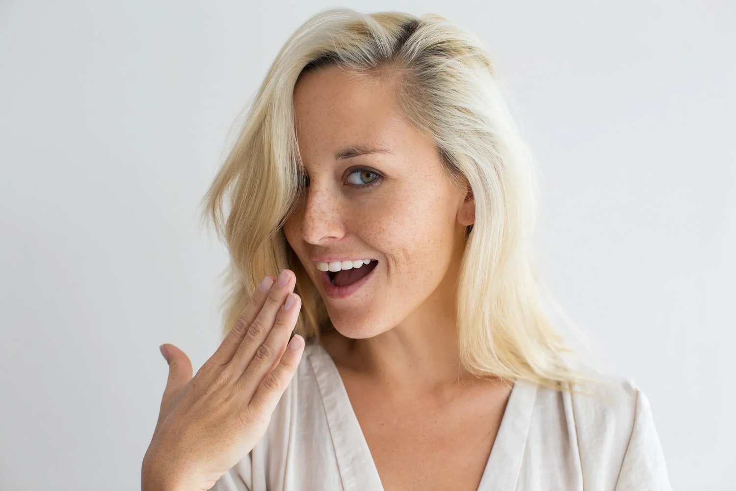 Mujer sonriendo mientras muestra sus uñas