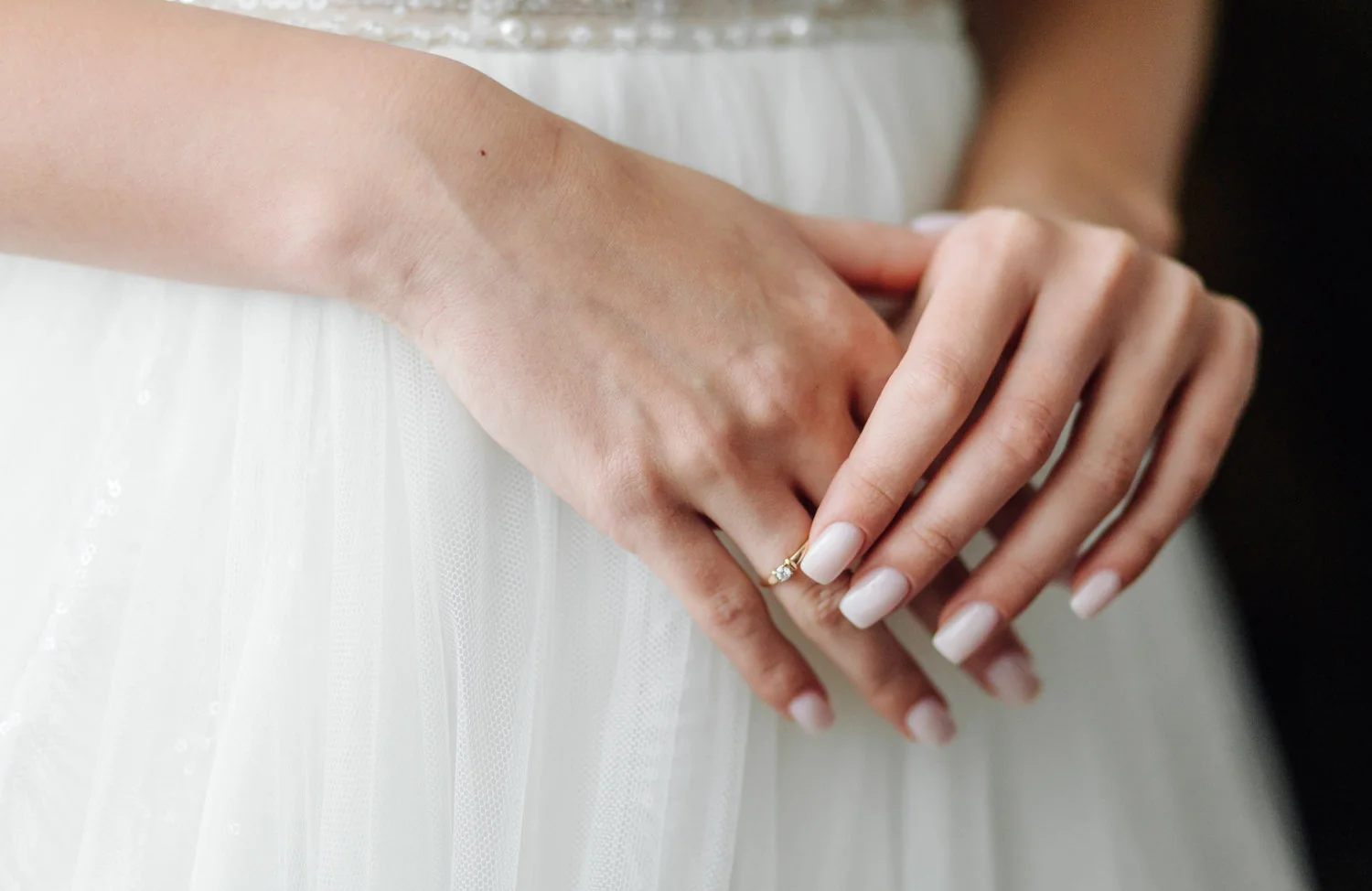 Manos de novia con manicure claro durante la preparación del matrimonio