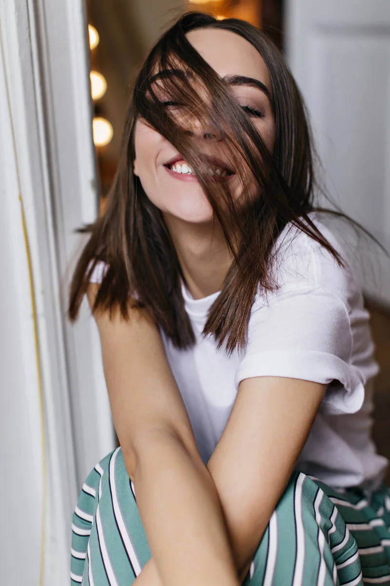 Mujer joven con cabello brillante después de una atención de peluquería