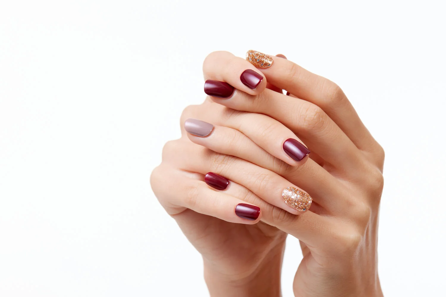 Manicure en tonos vino y dorado