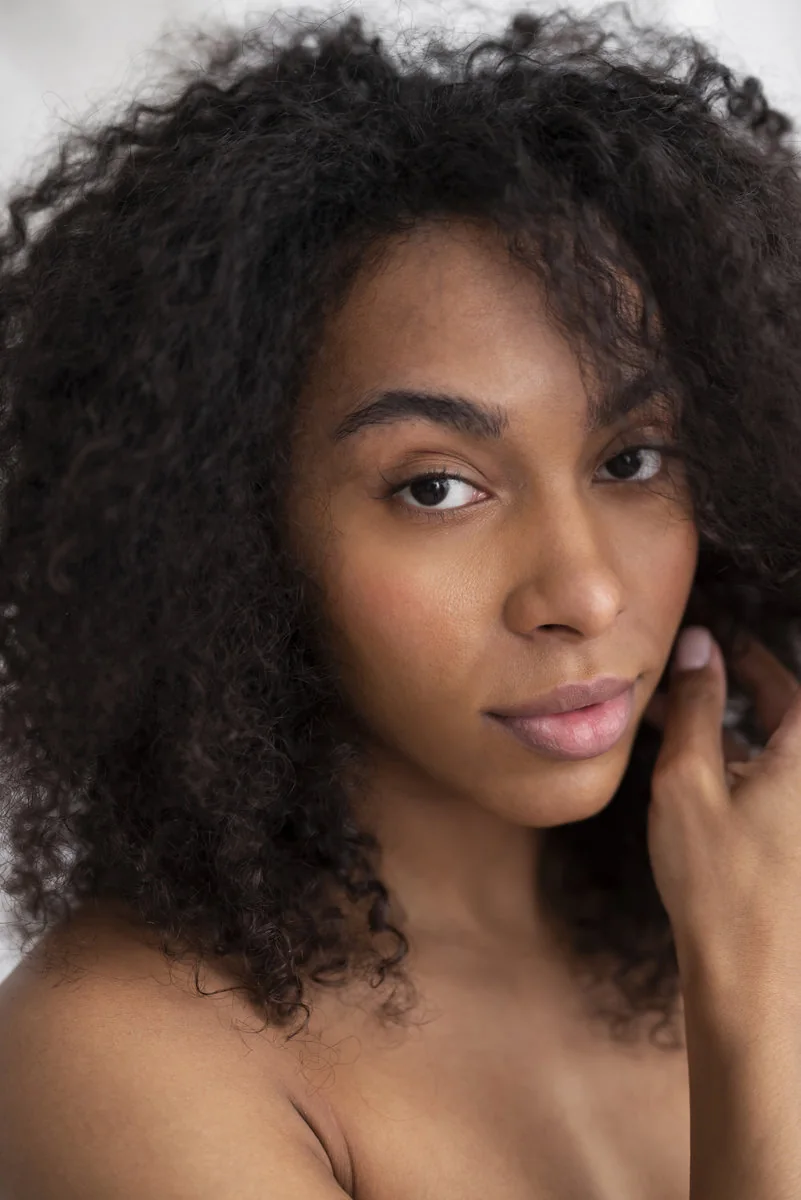 Mujer con cabello rizado natural en una propuesta de belleza inclusiva