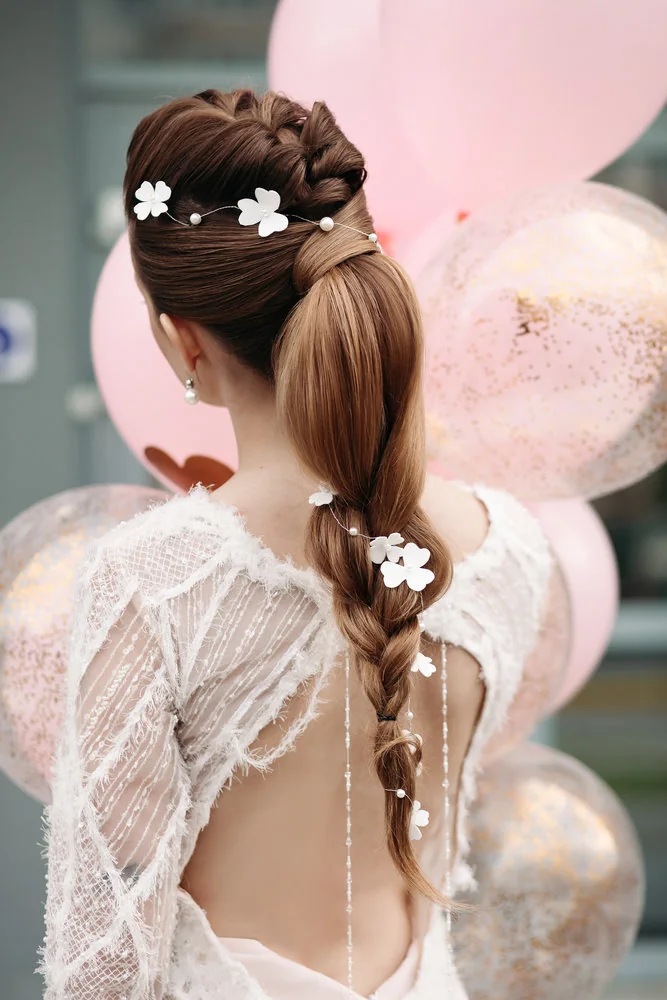 Peinado de novia con trenza y flores blancas