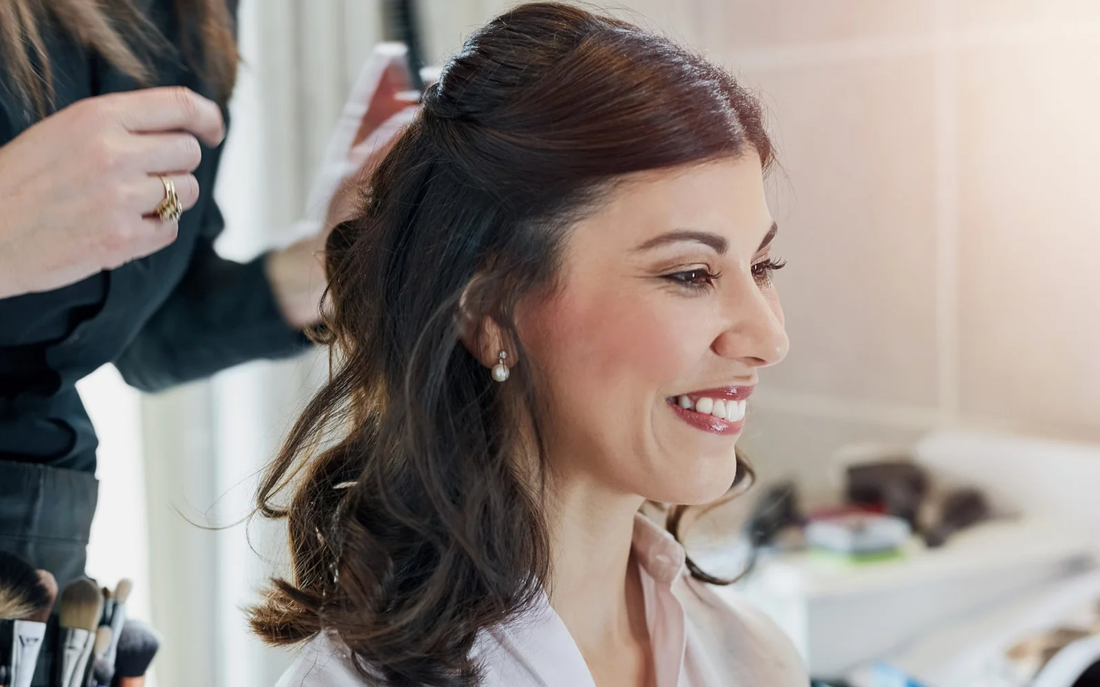 Novia con peinado recogido y maquillaje natural antes de su matrimonio